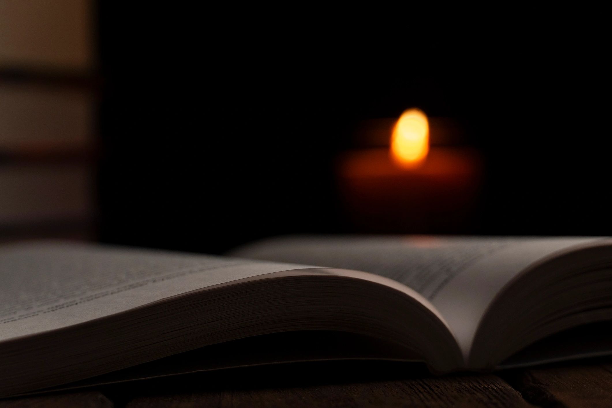 Open book illuminated by candlelight for a quiet prayerful atmosphere