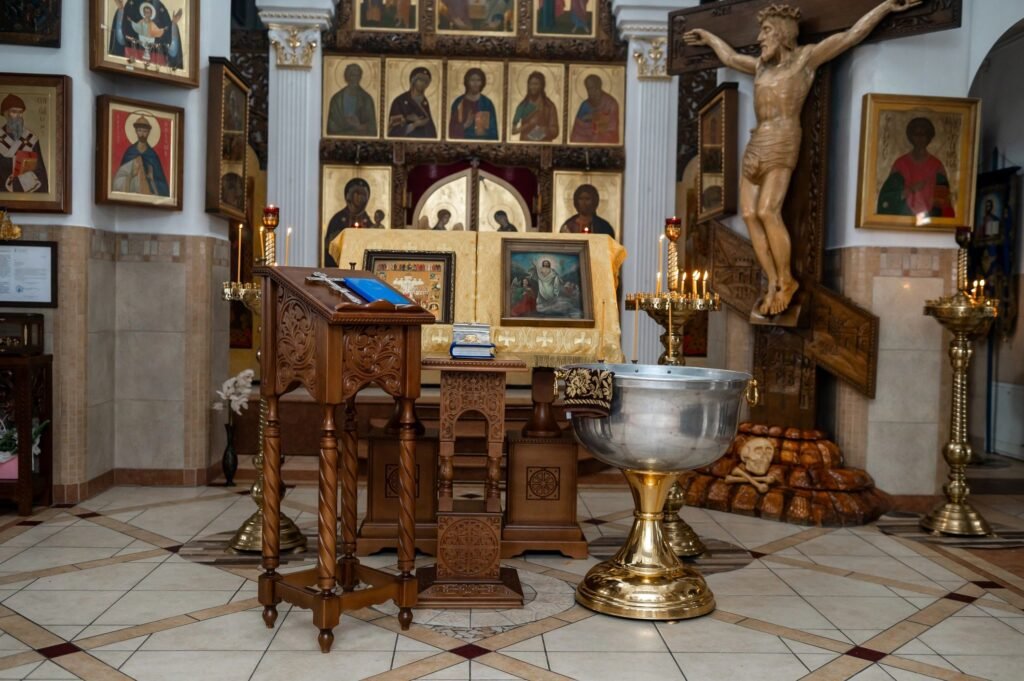 Silver Baptismal Font and Orthodox Icons on a Golden Altar in a Church Interior